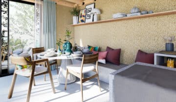 Studio de jardin lumineux avec table, chaises en bois et banquette confortable