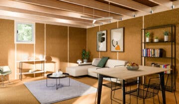 Studio de jardin aménagé avec canapé, table et étagères, murs en liège et plafond en bois
