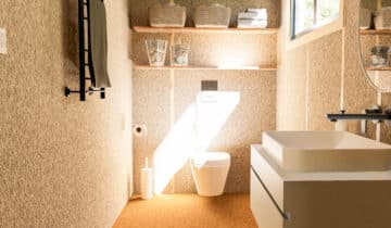 Bureau de jardin moderne avec sol en moquette, murs en liège et mobilier de salle de bain