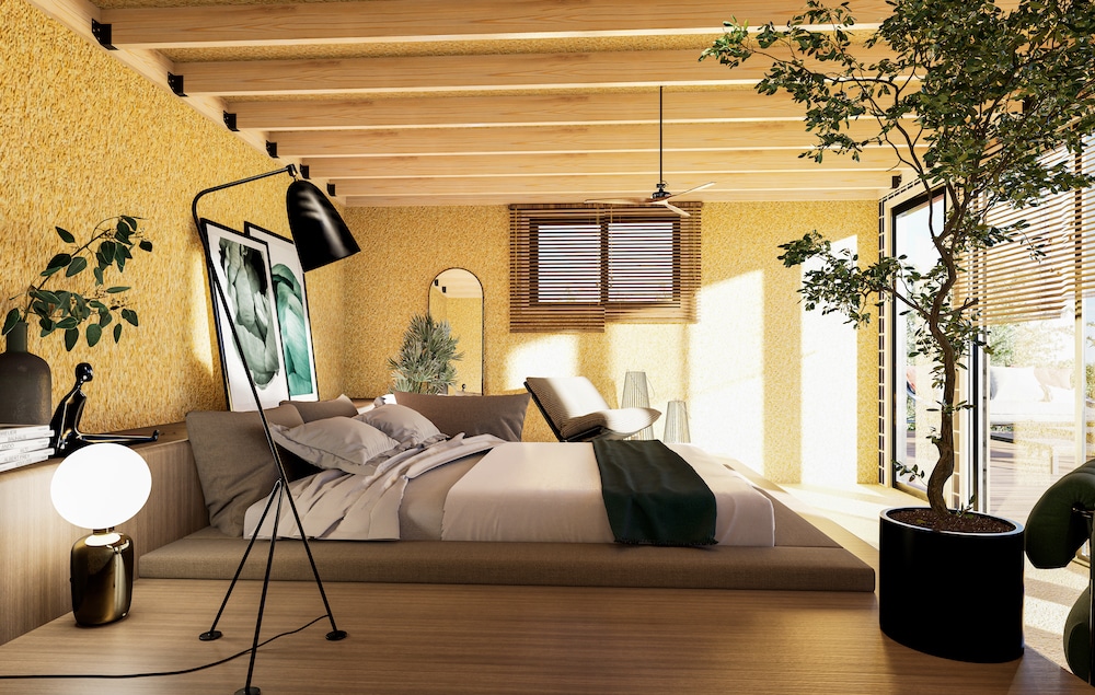 Intérieur de studio de jardin avec chambre, plafond bois et grande baie vitrée ouverte sur terrasse