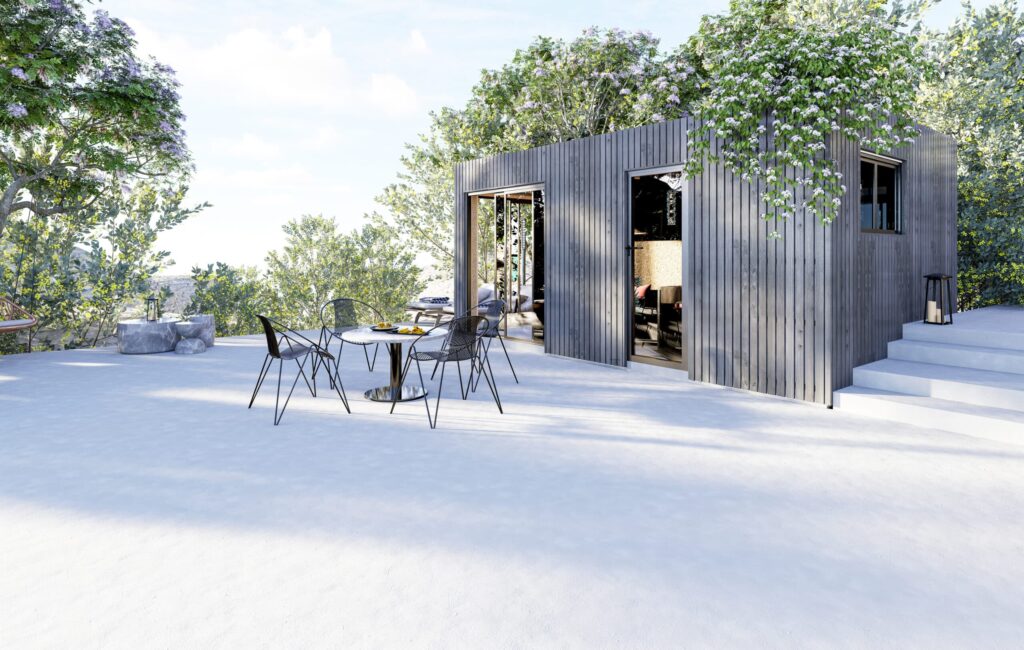 Studio de jardin habitable au bardage bois gris avec baies vitrées ouvertes sur terrasse végétalisée