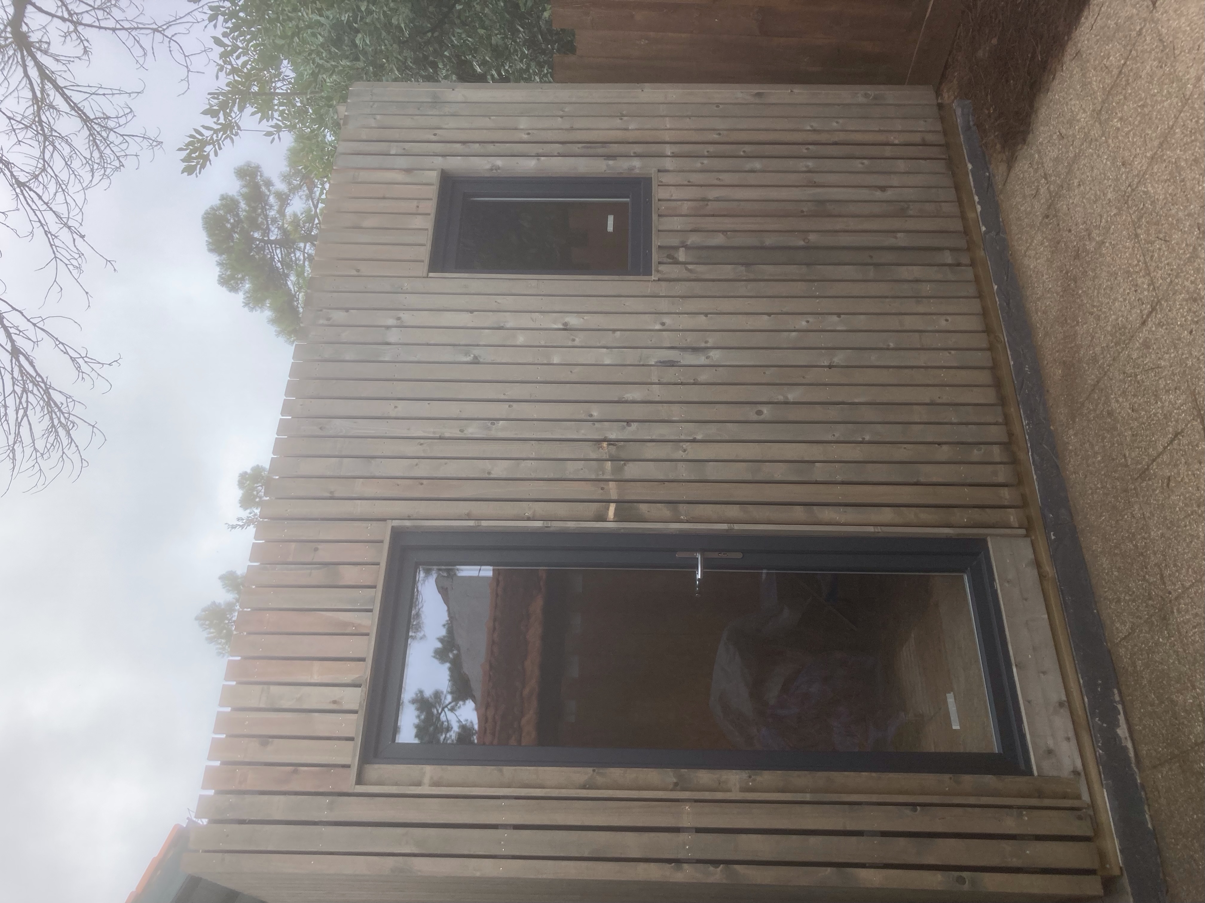 Studio de jardin en bois avec bardage horizontal et grandes fenêtres vitrées